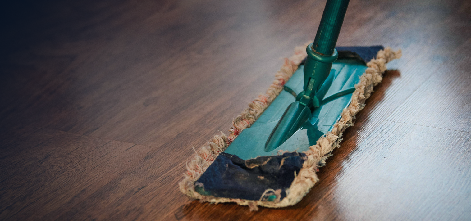 Mop with a blue cleaning pad on a wooden floor